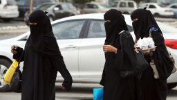 In a picture taken November 19, 2012, Saudi women walk with their shopping bags and drinks outside the Olaya mall in Riyadh. Women in Saudi Arabia, who are veiled in public and banned from driving, face further restrictions with a new law allowing airport security to report their movements to their male "guardians",  a move that is deemed by rights activists a form of "slavery" as any Saudi woman intending to travel must carry a "yellow slip" as a proof of consent granted to her.