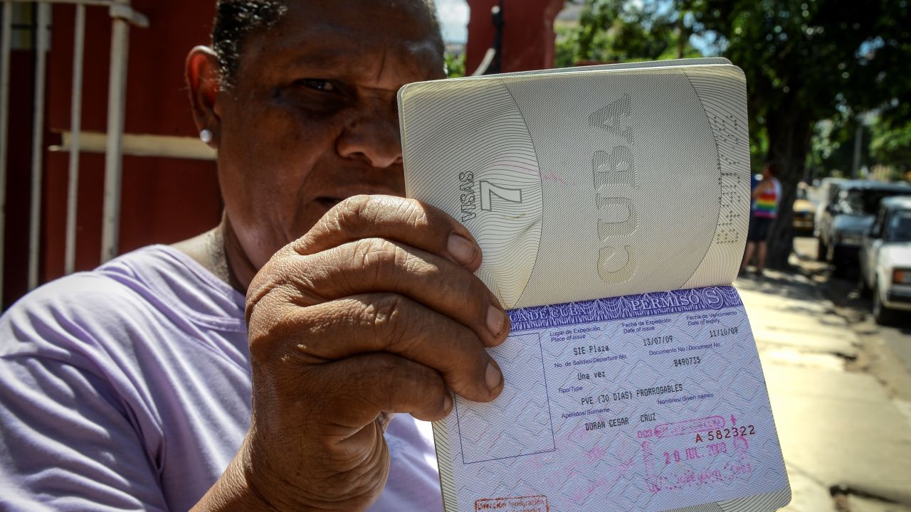 Cuban Cruz Duran shows her passport with a travel permission --aka white card-- on October 16, 2012 in Havana.