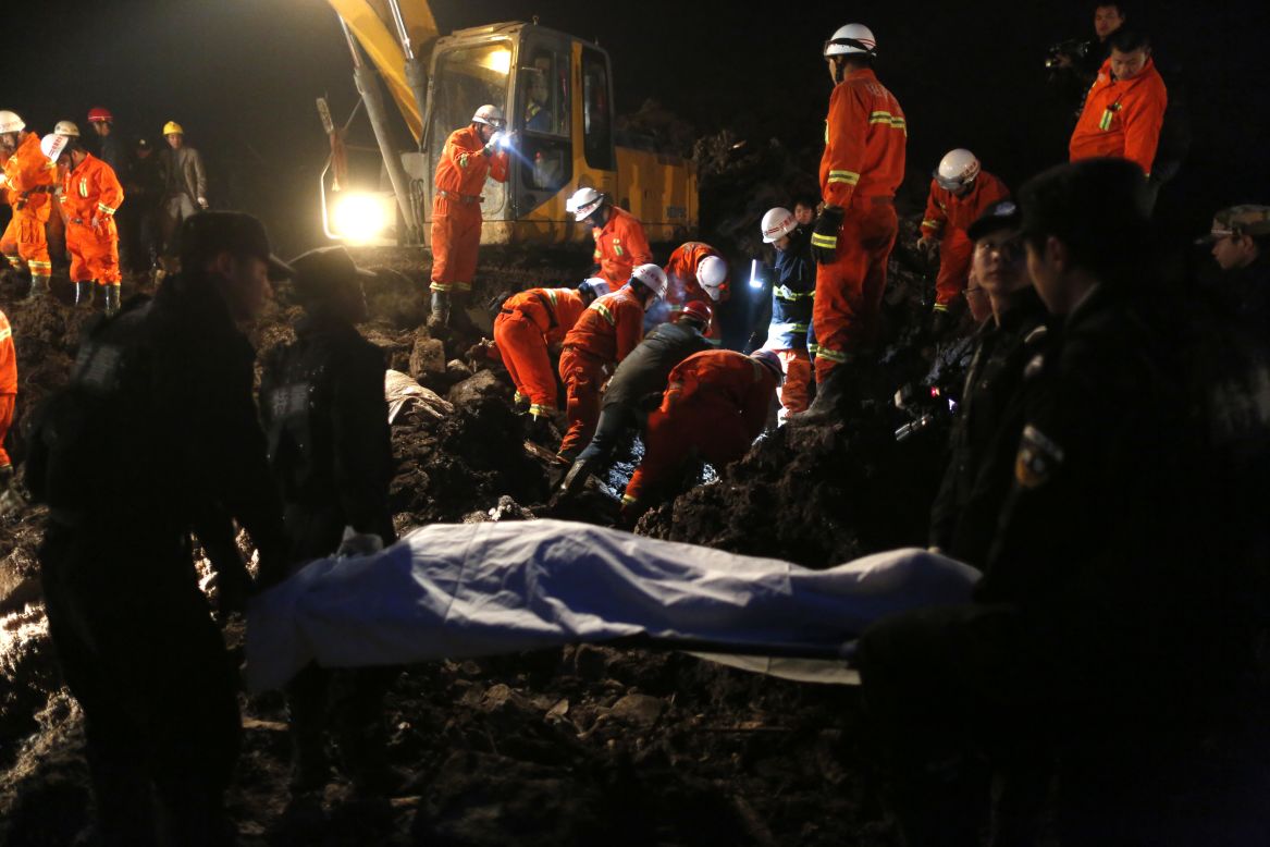 Rescuers carry a dead body from the area. The disaster prompted a massive search and rescue effort that included more than 20 excavators and front-end loaders.