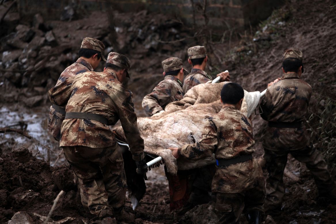 Another victim is carried away from the scene. The landslide has killed at least 46 people in the southwest China village, according to the state-run Xinhua news agency.