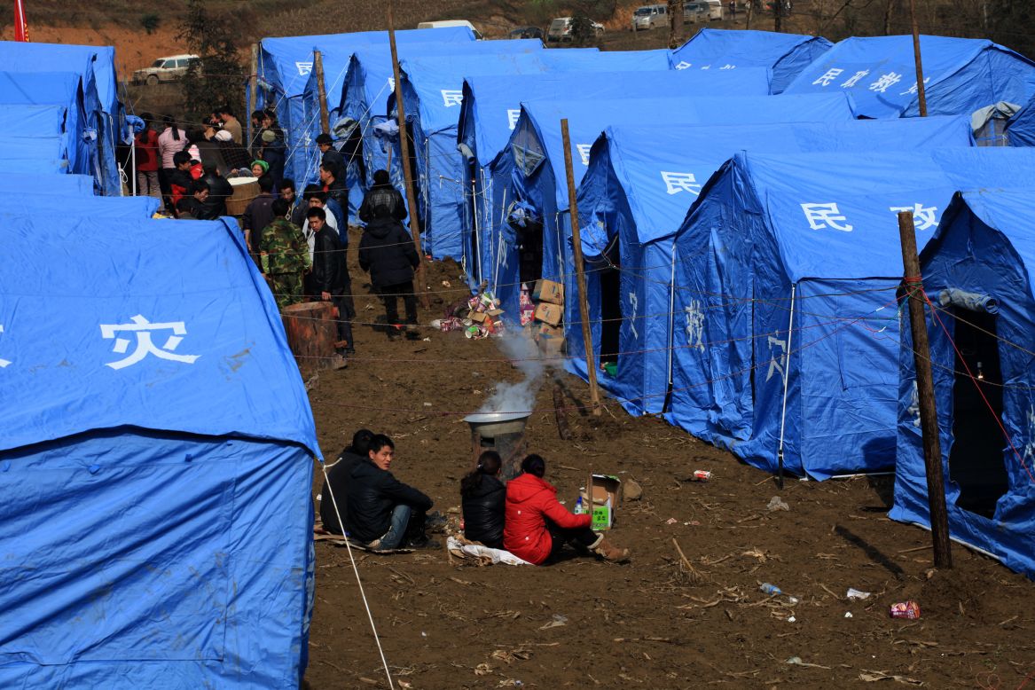Displaced residents gather near temporary tents on Saturday, January 12, after the rescue mission is finished.