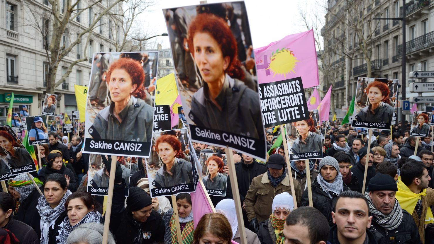 People hold posters of Sakine Cansiz, who was among three women found killed, during a demonstration Saturday in Paris.