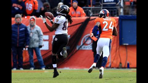 Torrey Smith of the Ravens catches a pass for a 59-yard touchdown in the first quarter against Champ Bailey of the Broncos on Saturday.