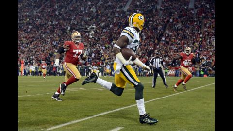 Cornerback Sam Shields of the Packers runs the ball back for touchdown after an interception against quarterback Colin Kaepernick of the 49ers in the first quarter of Saturday's playoff game.