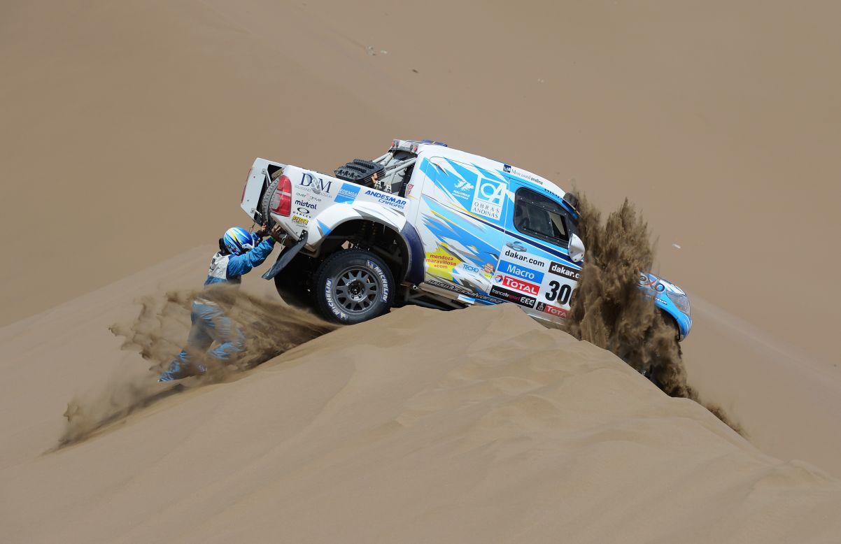 Lucio Alvarez and co-driver Ronnie Graue of Team Toyota try to move their stranded truck during the sixth stage from Arica to Calama, Chile, on Thursday, January 10.