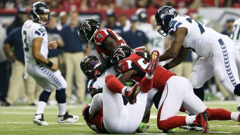Akeem Dent and Stephen Nicholas of the Falcons tackle Marshawn Lynch of the Seahawks in the first quarter on Sunday.