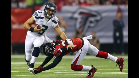 Quarterback Russell Wilson of the Seahawks tries to avoid the Falcons' Jacquizz Rodgers in the first quarter Sunday.