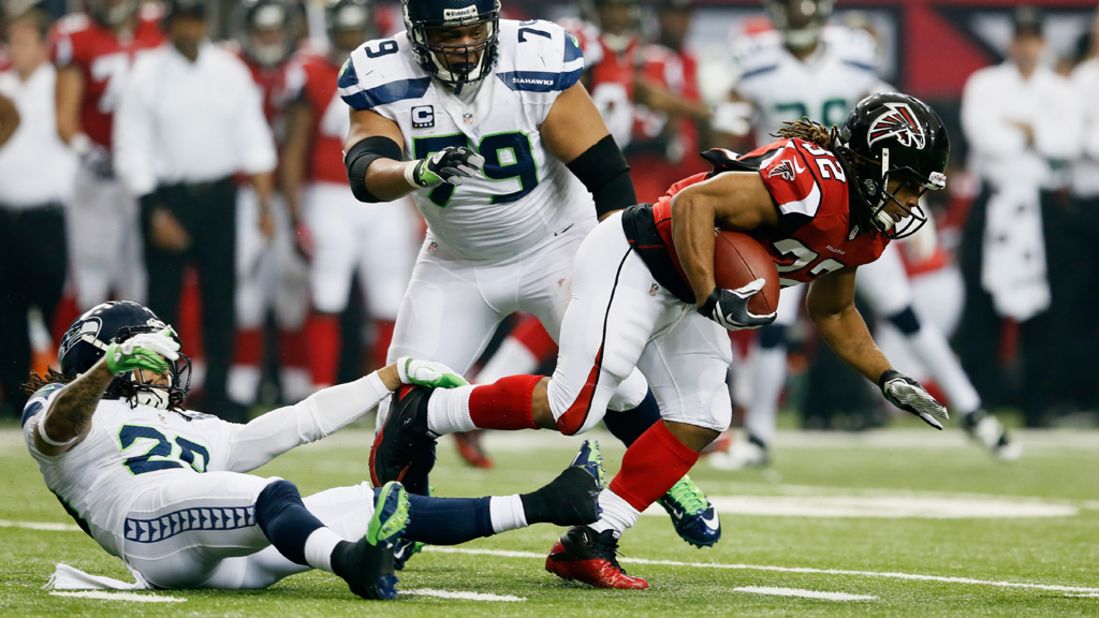 Jacquizz Rodgers of the Falcons breaks the tackle of Seattle's Red Bryant and gets past Earl Thomas on Sunday.