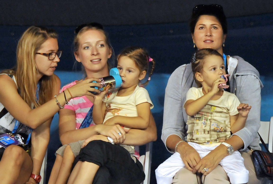 His wife Mirka, right, sits with their twins while the 17-time grand slam champion played in a Kids Day exhibition on January 12.