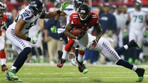 Julio Jones of the Atlanta Falcons is tackled by No. 50 K.J. Wright and No. 25 Richard Sherman of the Seahawks in the third quarter on Sunday.