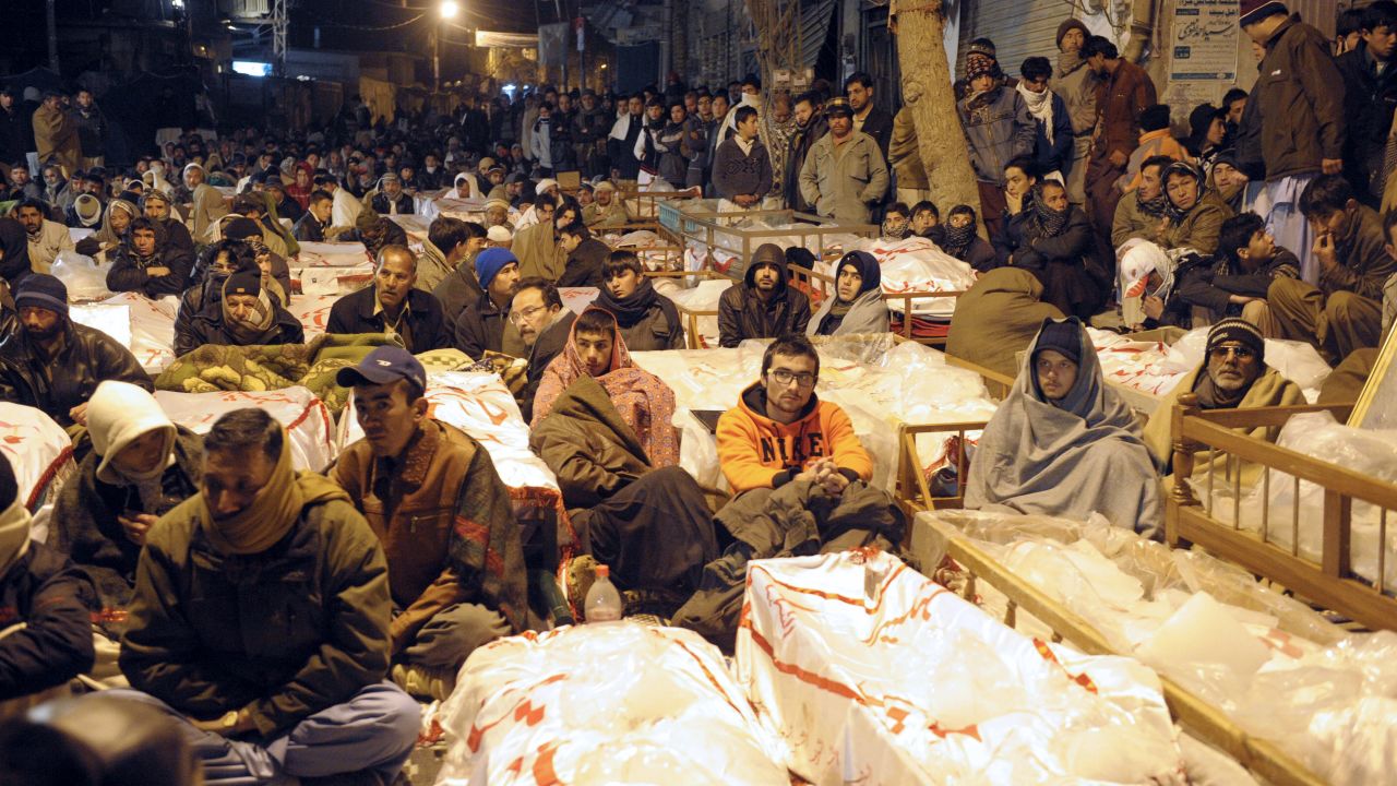 Pakistani Shiite Muslims demonstrate and sit between the coffins of bomb blast victims in Quetta on January 12, 2013. 