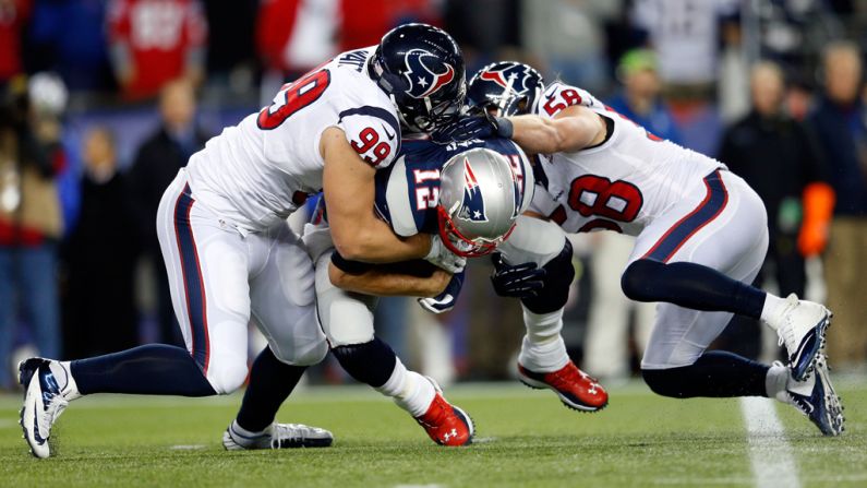 Texans players J.J. Watt, left, and Brooks Reed sack Patriots quarterback Tom Brady on Sunday.