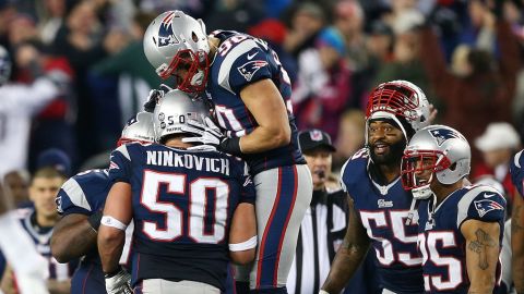 Rob Ninkovich of the New England Patriots, No. 50, celebrates with Niko Koutouvides after making an interception against the Houston Texans during the 2013 AFC divisional playoff game at Gillette Stadium in Foxboro, Massachusetts, on Sunday, January 13. The Patriots defeated the Texans 41-28.