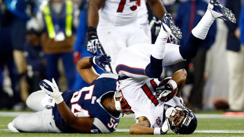 Dont'a Hightower of the New England Patriots tackles DeVier Posey of the Houston Texans.