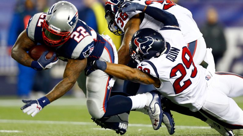 No. 38 Danieal Manning and No. 29 Glover Quin of the Houston Texans try to bring down Stevan Ridley of the New England Patriots.