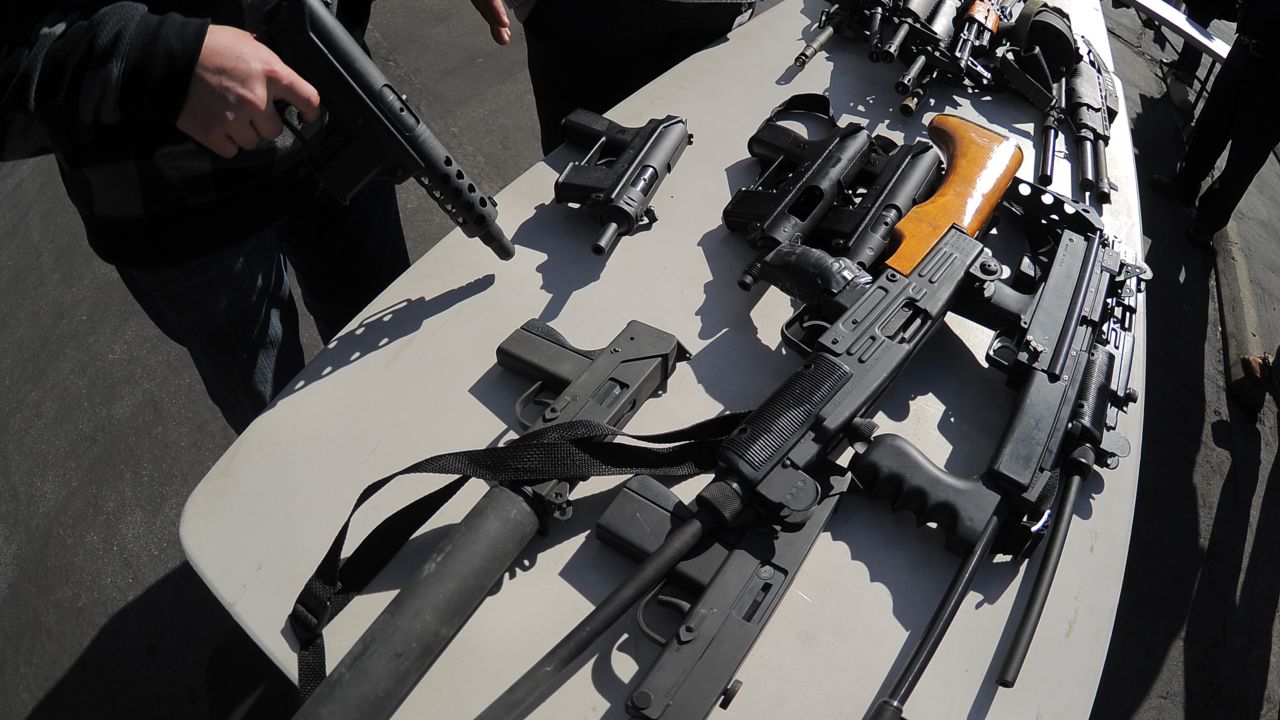 A police officer oversees assault weapons collected at the LAPD's gun buyback event on December 26, 2012.