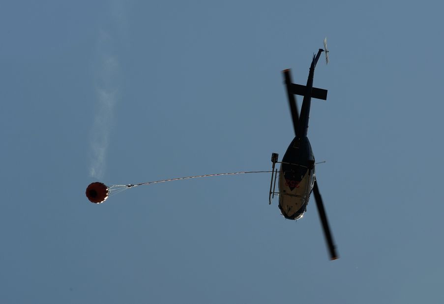 A water-bombing helicopter returns from a fire area to the town of Yass, in the southern part of New South Wales state, on Friday, January 11.