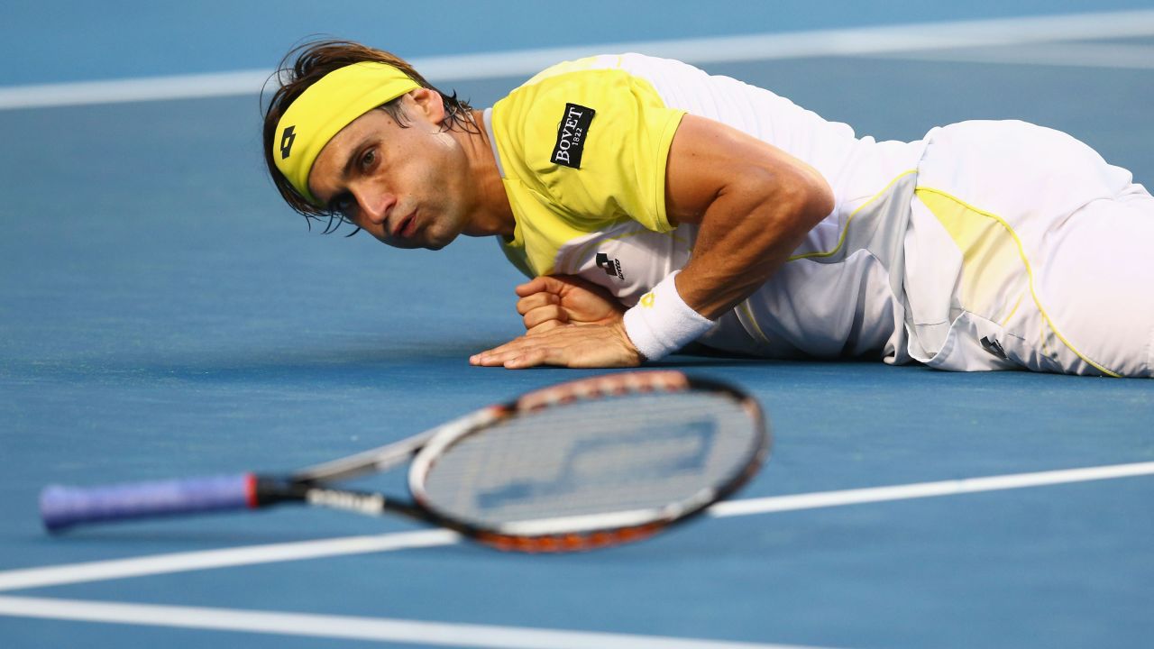 Spain's David Ferrer falls to the ground after playing a shot in his first-round match against Belgium's Olivier Rochus on January 14. Ferrer won 6-3 6-4 6-2.