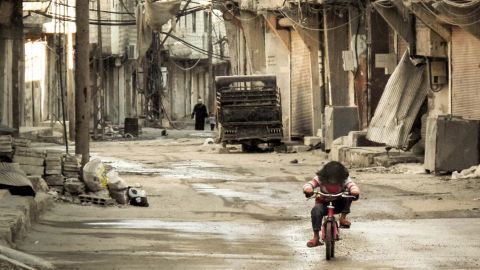 A Syrian girl rides her bicycle in an almost deserted street in Damascus, Syria on January 3, 2013.