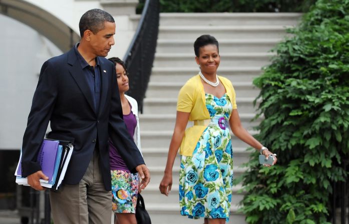 Obama has been known to wear dresses from mass retailer Talbots and accessorize them with signature pieces such as this sweater from Dear Cashmere and a belt by Sonia Rykiel, worn in July 2009, <a href="index.php?page=&url=http%3A%2F%2Fmrs-o.com%2Fnewdata%2F2009%2F7%2F5%2Fbon-voyage.html" target="_blank" target="_blank">according to Mrs. O</a>.