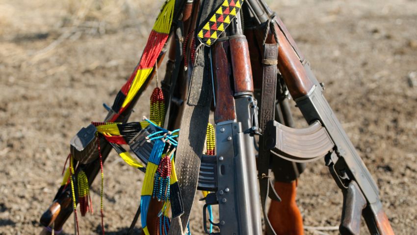 Ethiopia, Southwest Ethiopia, Omo River. While Karo men dance, they place their automatic rifles in a stack close at hand. Almost every man owns a gun- usually an AK 47 assault rifle- and keeps spare ammunition in a cartridge belt around his waist. Fights