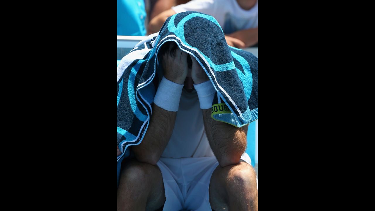 Brian Baker of the United States covers his head after injuring his knee in his second round match against compatriot Sam Querrey on January 16. After winning the first set in a tie breaker, Baker dropped out of the match two games into the second set.