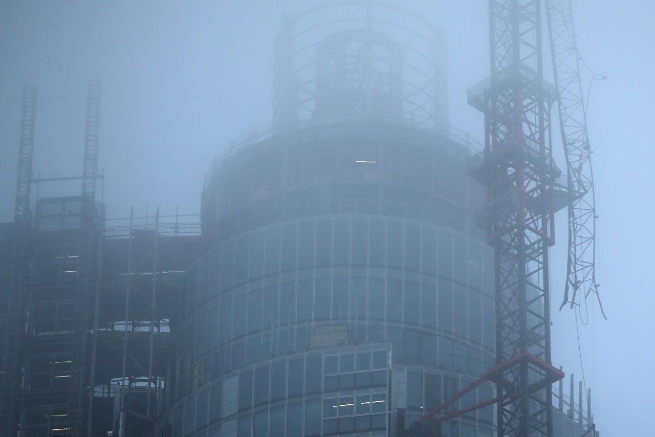 Fog surrounds a damaged crane attached to St Georges Wharf Tower after a helicopter reportedly collided with it.