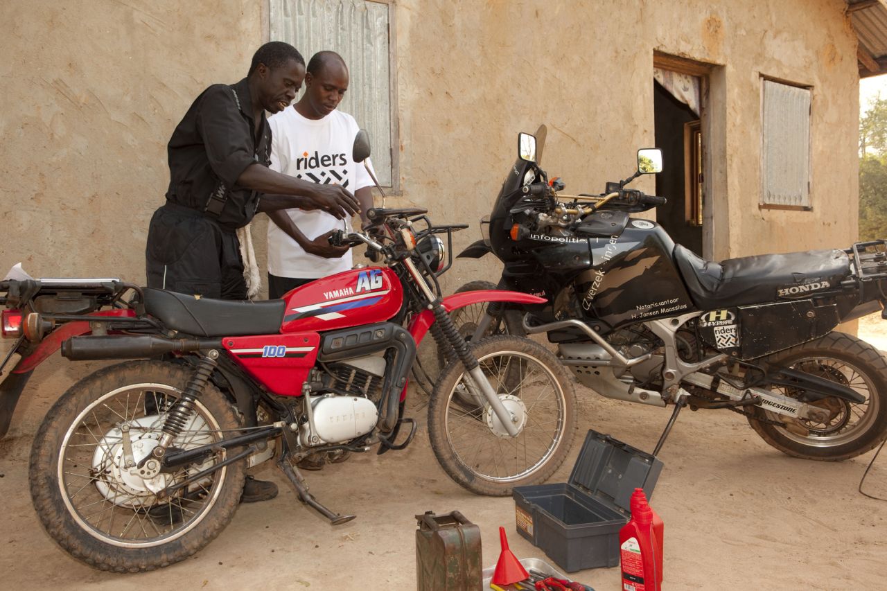 Saul Senghore, a RFH technician, provides a monthly service on Jallow's motorcycle. RFH employs local mechanics to regularly check all the vehicles it manages .