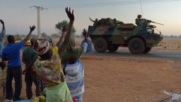 Malian people wave to French soldiers as a convoy of armoured vehicles leave Bamako and start a deployment to the north of Mali as part of the 'Serval' operations on January 15, 2013.