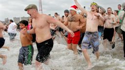 People run into the chilly water as they take part in the Coney Island Polar Bear Club's New Year's Day swim on January 1, 2013 in the Coney Island neighborhood of the Brooklyn borough of New York City. The annual event attracts hundreds who brave the icy Atlantic waters and temperatures in the upper 30's as a way to celebrate the first day of the new year. 