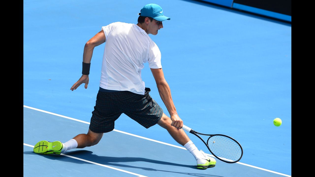Tomic twists around to get a return during his men's singles match against  Brands on January 17.