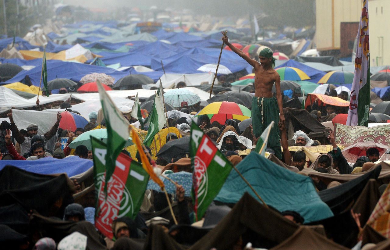 A supporter of Tahir-ul Qadri enjoys the rain at a protest rally in Islamabad on January 17.