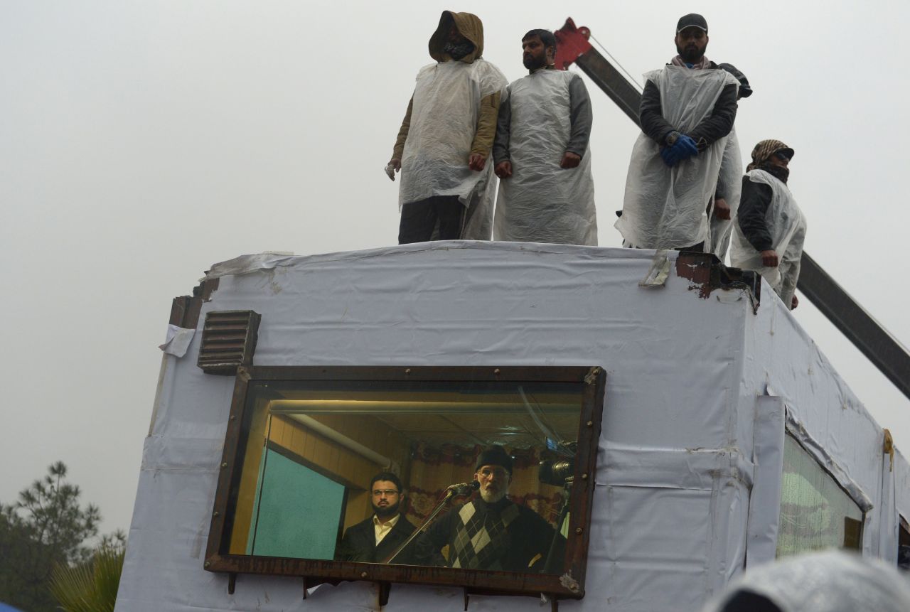 Tahir-ul Qadri (C-below) addresses his supporters from his makeshift room at a protest rally in Islamabad on January 17.