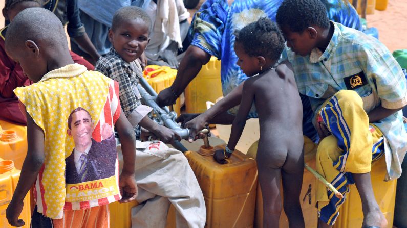 MAURITANIA: A child wearing a T-shirt depicting Obama gathers with other refugees at a water point in the M'bere refugee camp near Bassiknou on May 2, 2012.