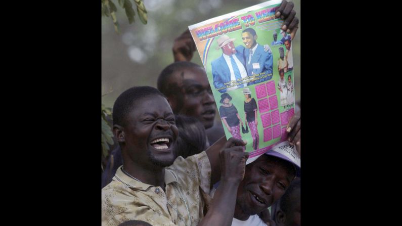 KENYA: A resident of Kisumu raises a poster bearing Obama's likeness after an HIV/AIDS test on August 26, 2006. Obama urged residents of the area to get tested for HIV and AIDS so they would know their status.
