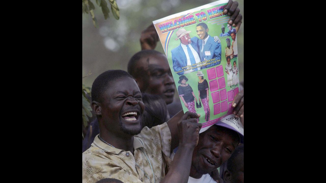 KENYA:  A resident of Kisumu raises a poster bearing Obama's likeness after an HIV/AIDS test on August 26, 2006. Obama urged residents of the area to get tested for HIV and AIDS so they would know their status.