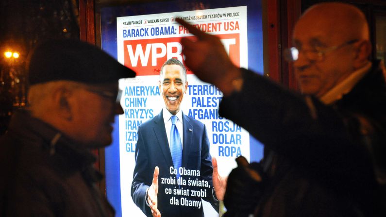 POLAND: Two men talk in front of an advertisement for a Polish weekly magazine in Warsaw on January 20, 2009.