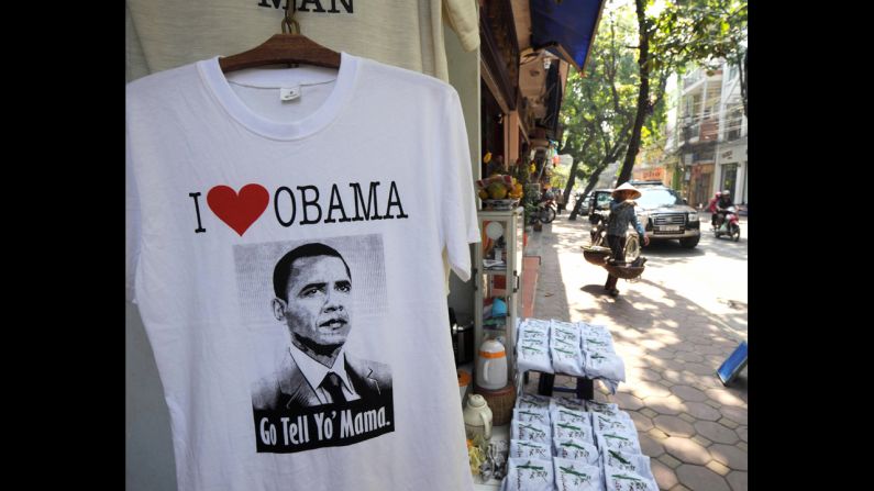 VIETNAM: A street vendor walks past a T-shirt shop in downtown Hanoi on November 13, 2008.