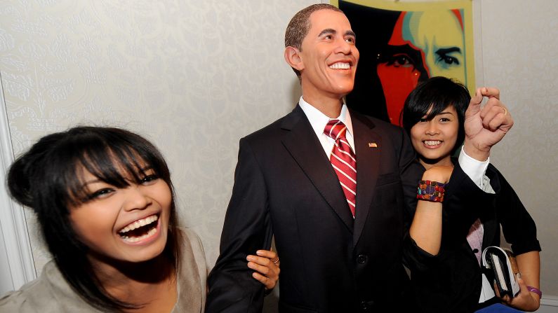 THAILAND: Visitors smile as they pose with a wax model of Obama displayed at the Louis Tussaud's Waxworks in Pattaya on November 13, 2009.