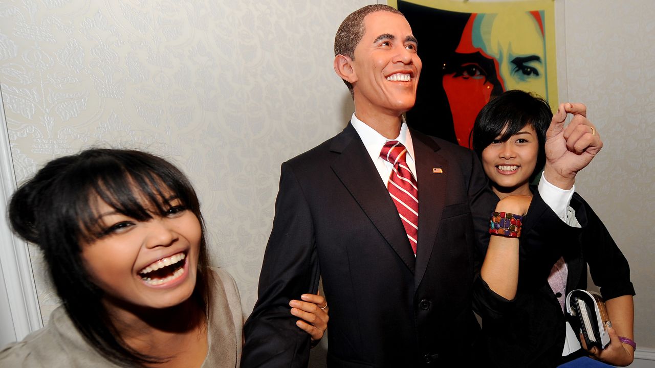 THAILAND: Visitors smile as they pose with a wax model of Obama displayed at the Louis Tussaud's Waxworks in Pattaya on November 13, 2009. 