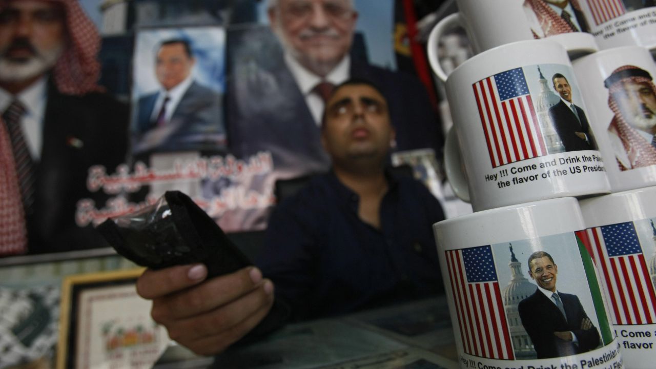 GAZA: A Palestinian shopkeeper sits near coffee mugs for sale with pictures of Obama and Hamas leader Ismail Haniya on November 2, 2008, in Gaza City. The mugs read "Hey!!! Come and drink the Palestinian coffee with the flavor of the US Presidential Election."
