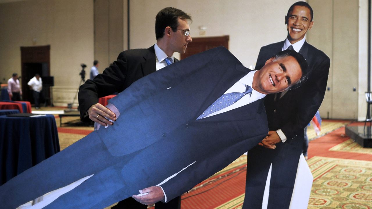 EL SALVADOR: An employee of the U.S. Embassy moves life-size figures of Obama and Romney at a hotel during preparations for the U.S. election night in San Salvador on November 6, 2012.