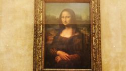 PARIS - AUGUST 24:  The famous Leonardo Da Vinci painting " The Mona Lisa" is seen on display in the Grande Galerie of the Louvre museum on August 24, 2005 in Paris, France. Dan Brown is the author of numerous  bestsellers, including Digital Fortress, Angels and Demons, and Deception Point. His acclaimed novel "The Da Vinci Code"has become one of the most widely read books of all time.  (Photo by Pascal Le Segretain/Getty Images)