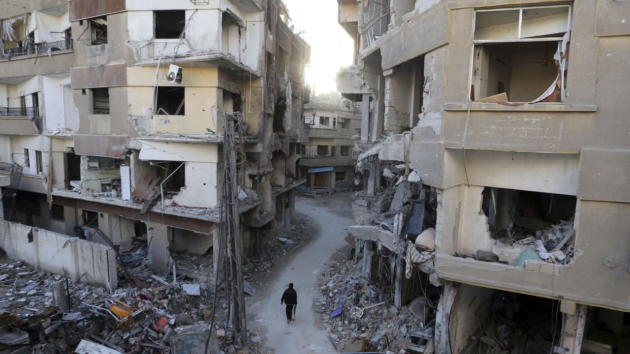 A Free Syrian Army fighter walks between buildings damaged during airstrikes in Damascus on January 19.