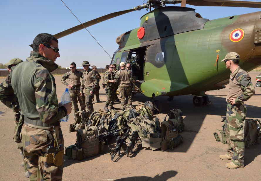 French soldiers of the 5th Combat Helicopter Regiment stand with their equipment in front of a helicopter on January 19 at an airbase near Bamako, Mali. French Defense Minister Jean-Yves Le Drian said on January 19 that France now had 2,000 troops on the ground in Mali as part of a drive against Islamist militants holding the north of the country.