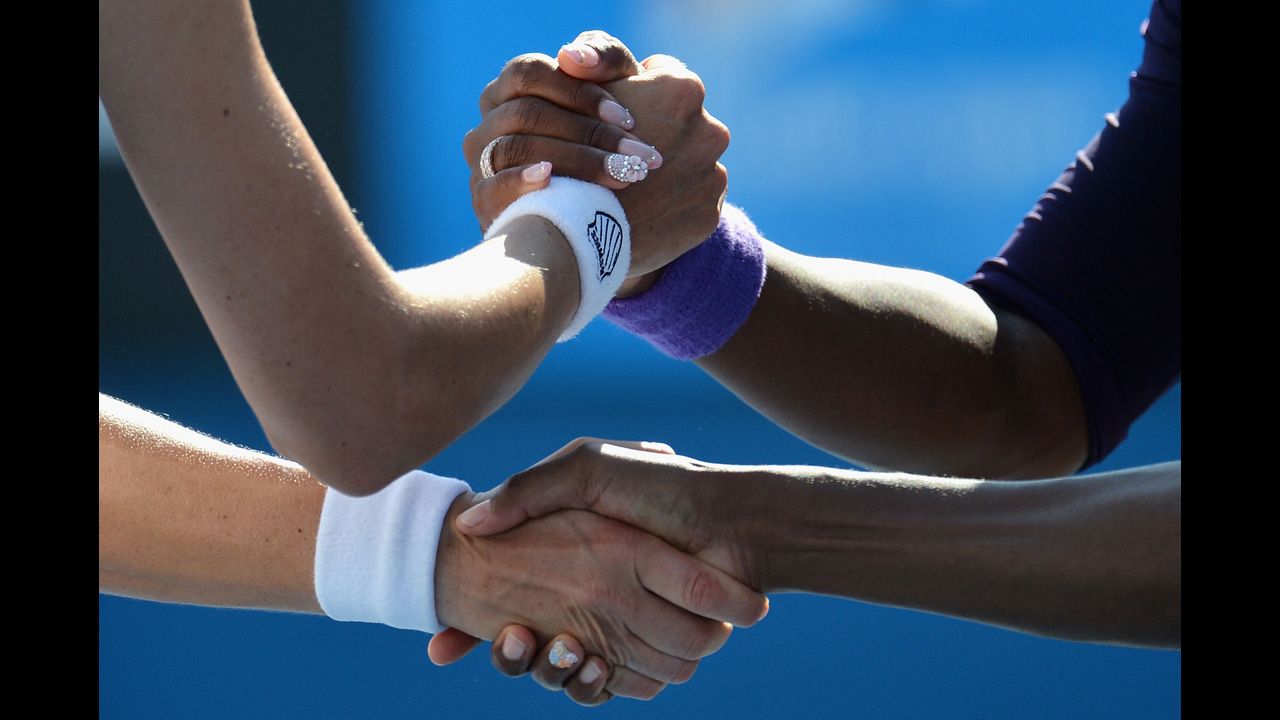 Venus  and Serena Williams of the U.S. are congratulated by Russian Nadia Petrova and Slovenian Katarina Srebotnik after winning their third-round doubles match on January 20.