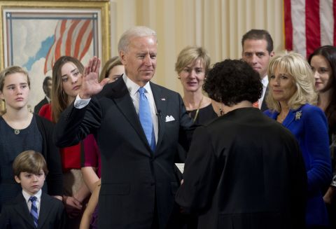 Biden takes the oath of office from U.S. Supreme Court Justice Sonia Sotomayor at the Naval Observatory on Sunday as his wife, Jill Biden, right,  looks on.