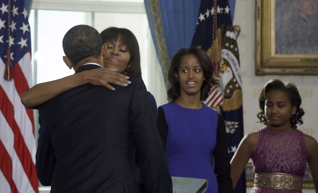 Michelle Obama embraces her husband after he took the oath of office January 20. Daughters Malia, left, and Sasha watch from the side.