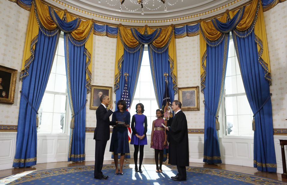 President Barack Obama takes the oath of office Sunday from U.S. Chief Justice John Roberts as first lady Michelle Obama holds the Bible, with daughters Malia, 14, and Sasha, 11, by their parents' side in the White House Blue Room. 