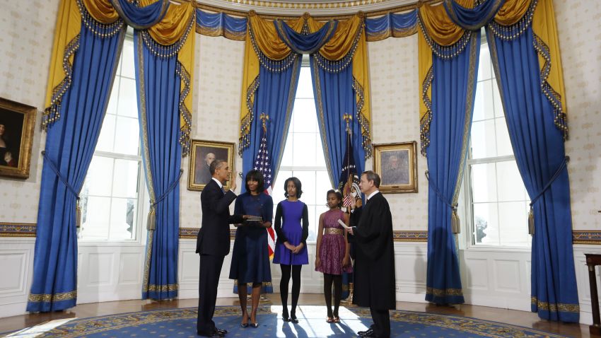 WASHINGTON - JANUARY 20:  U.S President Barack Obama (L) takes the oath of office from U.S. Supreme Court Chief Justice John Roberts (R) as first lady Michelle Obama (2nd L) holds the bible and daughter Malia (C) and Sasha looks on in the Blue Room of the White House January 20, 2013 in Washington, DC. Obama and U.S. Vice President Joe Biden were officially sworn in a day before the ceremonial inaugural swearing-in.  (Photo by Larry Downing-Pool/Getty Images)